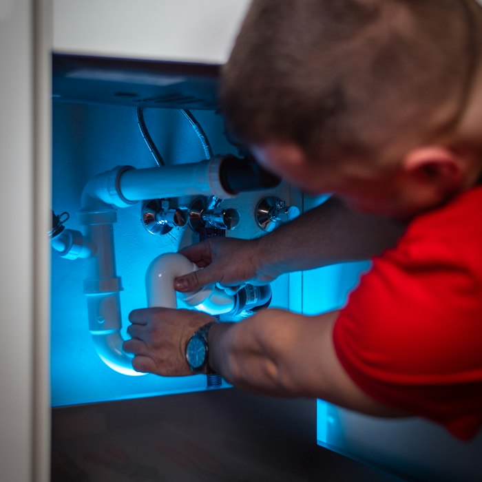 Emergency plumber isolating an overflowing toilet