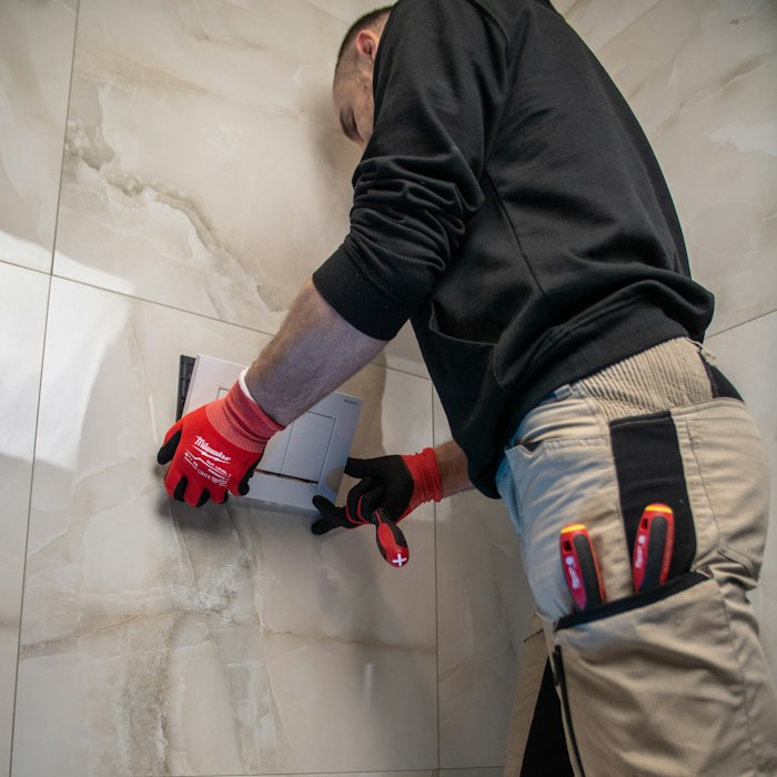 Plumber renewing a toilet pan connector flange